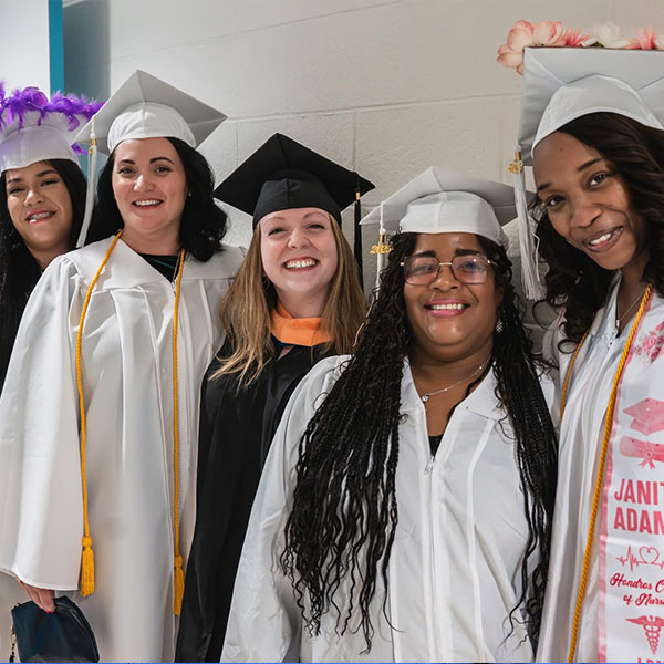 Professor Kayla Smith of the Detroit campus with students at commencement